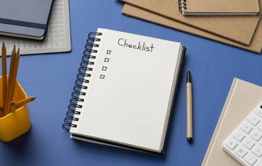 Top view notebook with checklist on desk - Attribut alt par défaut.